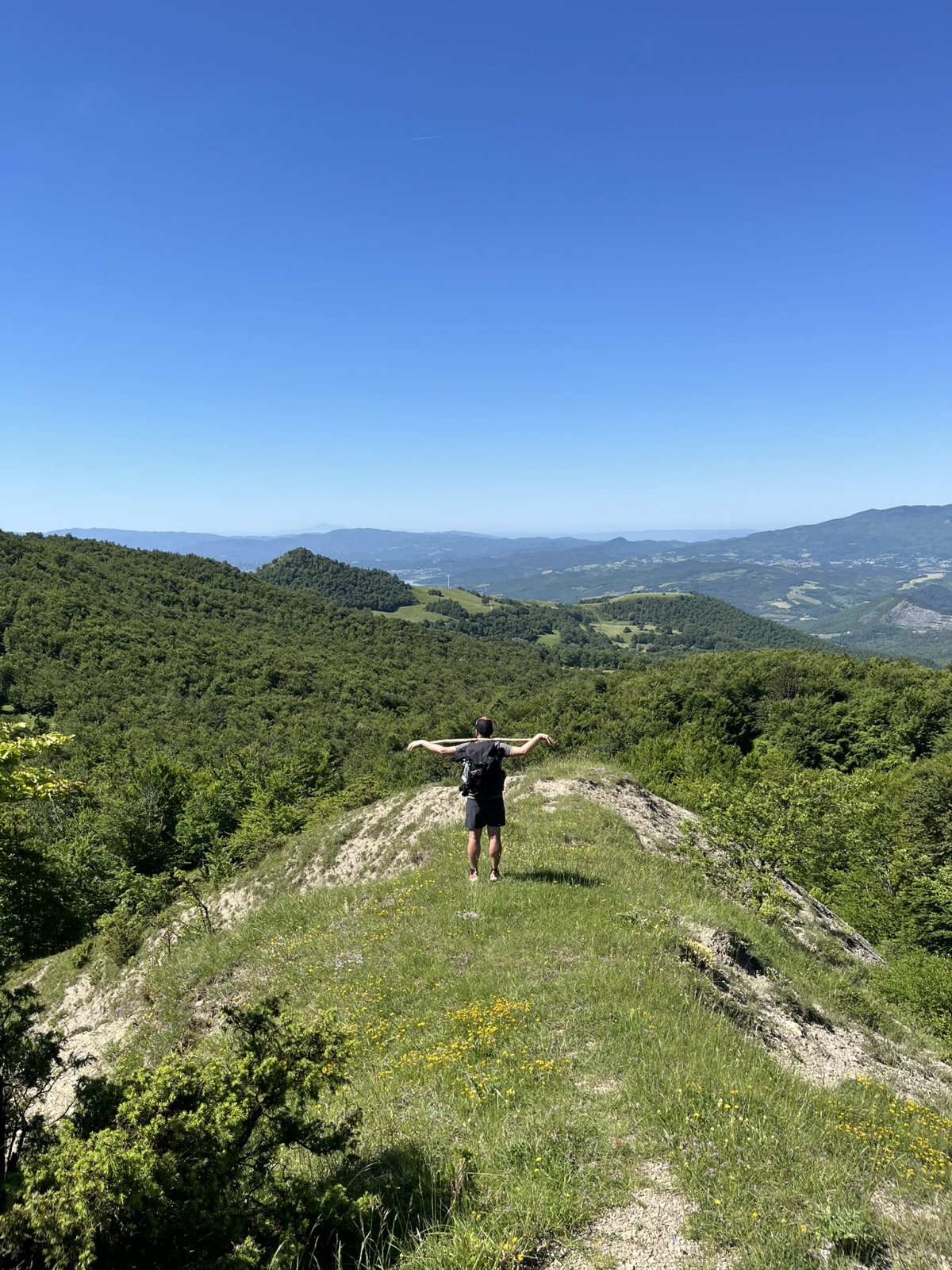 Marco di spalle su un crinale dell'Appennino, braccia aperte.